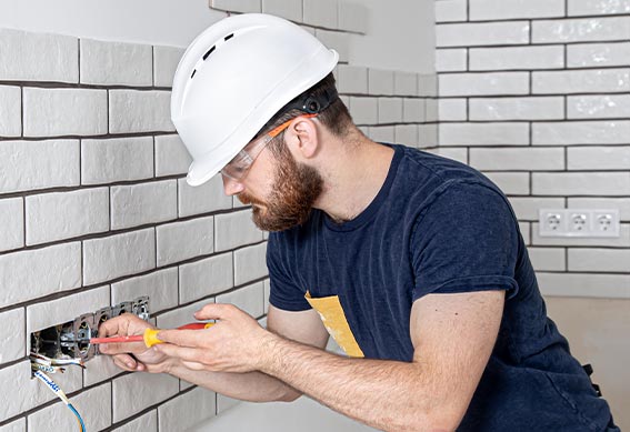 Homme qui change une prise électrique